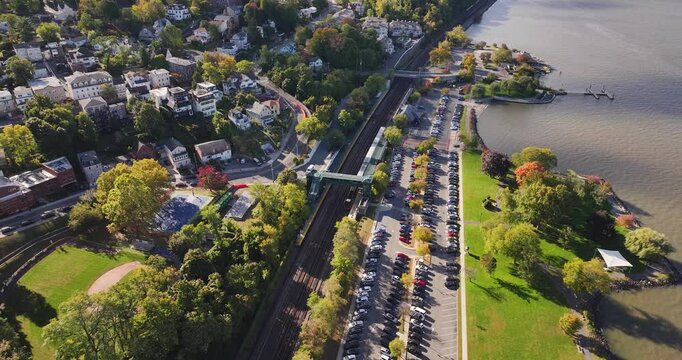 Morning fall, autumn, October 2024, aerial video of a commuter train traveling through the Village of Dobbs Ferry, NY, USA