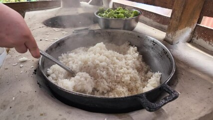 Preparation of white rice in rural area, ladle stirring creole food, Dominican Republic, Close-up
