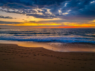 Obraz premium Pretty Sunrise at the seaside with rain clouds
