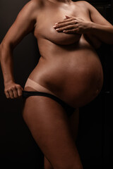Naklejka premium Pregnant woman pulls back her panties showing instant tan. Vertical photo. 