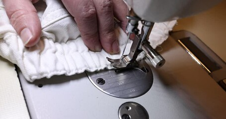 Close-up of a sewing machine working on white fabric