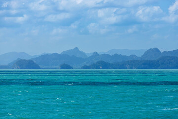 Seascape view of the ripple in turquoise sea with many hills island and many layers mountain background in the morning