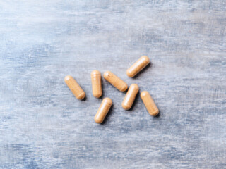 Korean Ginseng capsules. Concept for a healthy dietary supplementation. Wooden background. Top view.  Soft focus. Close up.	