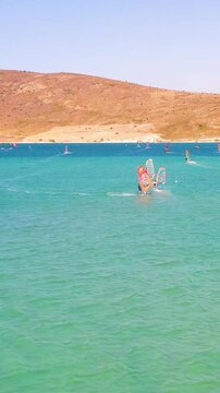 Vertical video of windsurfers - high quality aerial shot with drone of surfers windsurfing on Izmir beach in Aegean Sea Turkey Izmir