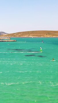 Vertical video of windsurfers - high quality aerial shot with drone of surfers windsurfing on Izmir beach in Aegean Sea Turkey Izmir
