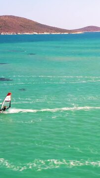 Vertical video of windsurfers - high quality aerial shot with drone of surfers windsurfing on Izmir beach in Aegean Sea Turkey Izmir