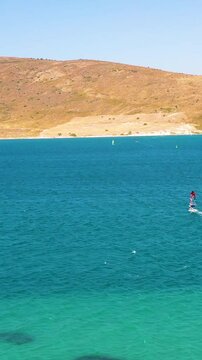 Vertical video of windsurfers - high quality aerial shot with drone of surfers windsurfing on Izmir beach in Aegean Sea Turkey Izmir