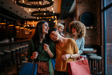 Obraz premium Beautiful women with shopping bags in the city cafe, shopping, tourism and happy people concept
