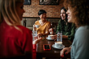Happy young people enjoy coffee and chat, gathering in a relaxed and social environment.
