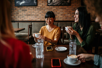 Happy young people enjoy coffee and chat, gathering in a relaxed and social environment.