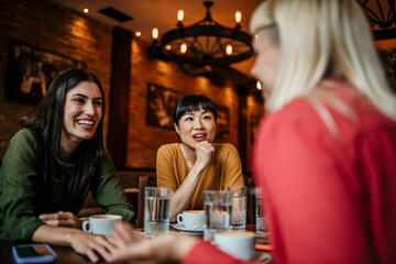 A group of friends catch up over coffee in a cozy cafe, taking a break from their busy lives to spend time together and reconnect