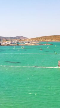 Vertical video of windsurfers - high quality aerial shot with drone of surfers windsurfing on Izmir beach in Aegean Sea Turkey Izmir