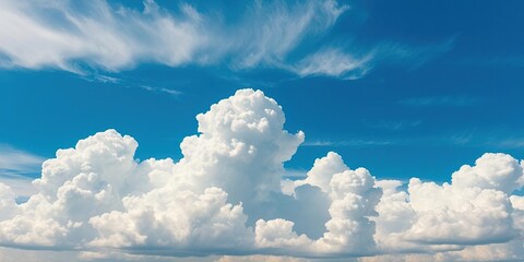 A majestic blue summer sky with towering cumulus clouds and a few stray wisps of cirrus, landscape, atmospheric effects