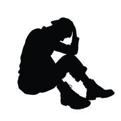 A woman is sitting on the ground with her head in her hands. She is wearing a black shirt and black pants