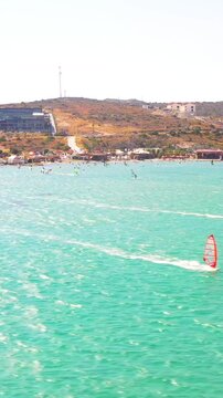 Vertical video of windsurfers - high quality aerial shot with drone of surfers windsurfing on Izmir beach in Aegean Sea Turkey Izmir