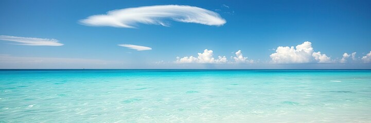 Fototapeta premium A wispy cloud formation floats above a vibrant turquoise ocean on a bright summer afternoon, cloud, formation