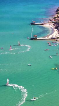 Vertical video of windsurfers - high quality aerial shot with drone of surfers windsurfing on Izmir beach in Aegean Sea Turkey Izmir