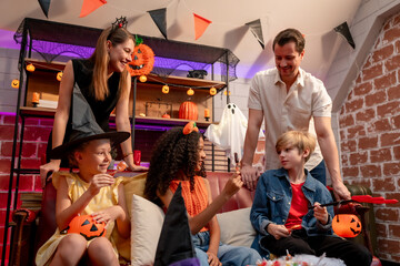Multiracial family celebrating Halloween party together in house. 