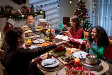 Multiracial family exchanging presents during Christmas party at home.