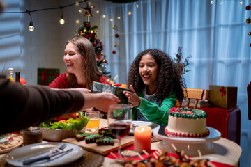 Multiracial family exchanging presents during Christmas party at home. 
