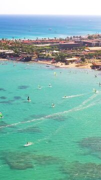 Vertical video of windsurfers - high quality aerial shot with drone of surfers windsurfing on Izmir beach in Aegean Sea Turkey Izmir