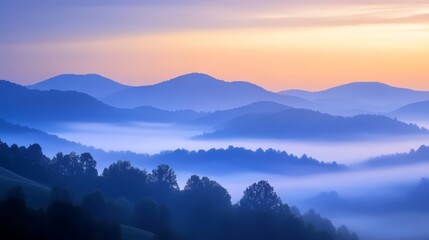 Obraz premium Misty sunrise over rolling hills with a soft, blue and orange sky.