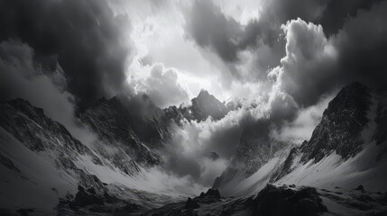 Dramatic black and white image of a mountain range with a cloudy sky.