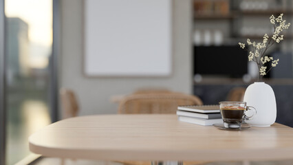 A close-up wooden table by the window in a contemporary and comfortable coffee shop.