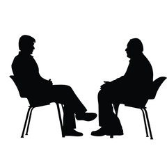 Two men are sitting in chairs and talking. One of the men is wearing a tie. The chairs are black