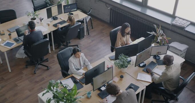 Top view of people office employees working at desks in modern open space workplace. Career development and coworking center concept.
