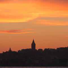 Galata Tower silhouette against a fiery orange Istanbul sunset