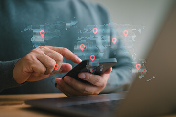 Businessman using smartphone and laptop to search map with geolocation points. Synchronize GPS,...