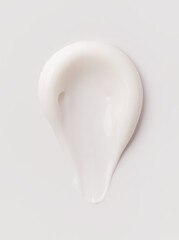 creamy smear of white cosmetic texture on gray background skin care concept
