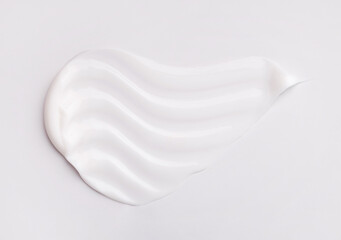 cosmetic smear of creamy texture on gray background