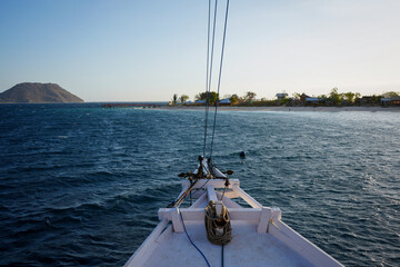 Ship Prow heading towards Tropical Island at Sunset 