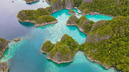 Aerial view of exotic island with turquoise water in Raja Ampat.