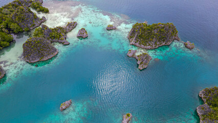 Aerial view of exotic island with turquoise water in Raja Ampat.