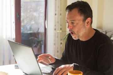 Mature man with laptop working at his workplace