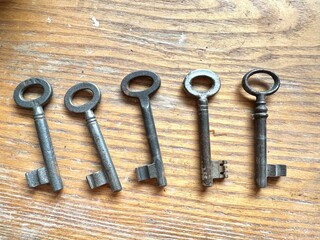 Old iron key on wooden background