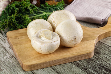 White champignon mushrooms heap over board