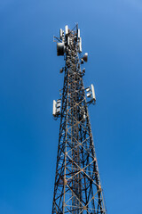 Communications cell tower mobile phone data againts clear blue sky