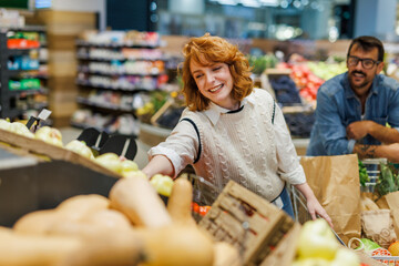 Young couple buying fresh vegetables at the supermarket