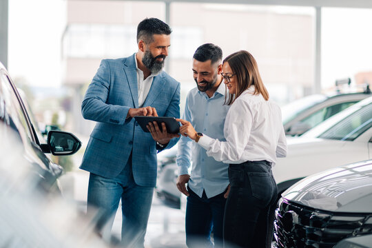 Consultation on vehicle choices using a tablet in dealership.