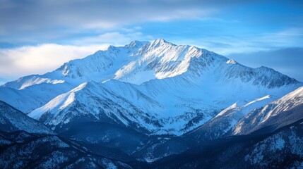 Obraz premium A breathtaking snow-capped mountain range under a clear blue sky, showcasing the beauty of nature's peaks and valleys.