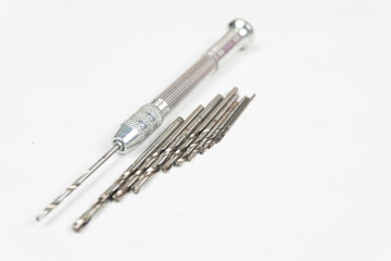 Silver hand drill with several drill bits of different sizes for drilling small objects