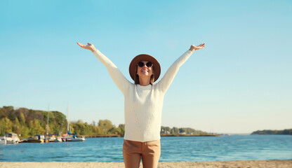 Happy smiling traveler woman on sunny beach, joyful girl enjoying on sea coast background