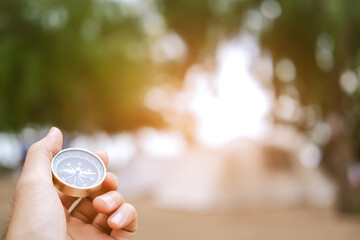 holding compass on tree mountain and sea blurry background. Using wallpaper or background travel or navigator image..
