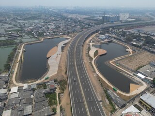 Aerial view of road, lake, bridge, village, and wetlands in jakarta 