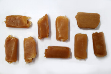 Unwrapped caramels on a white background