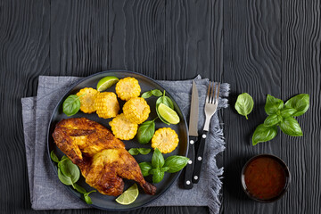 half of bbq chicken with corn cobs coins and basil
